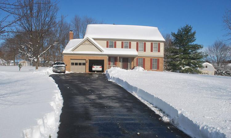 Residential driveway and walkway cleared to the pavement after a storm