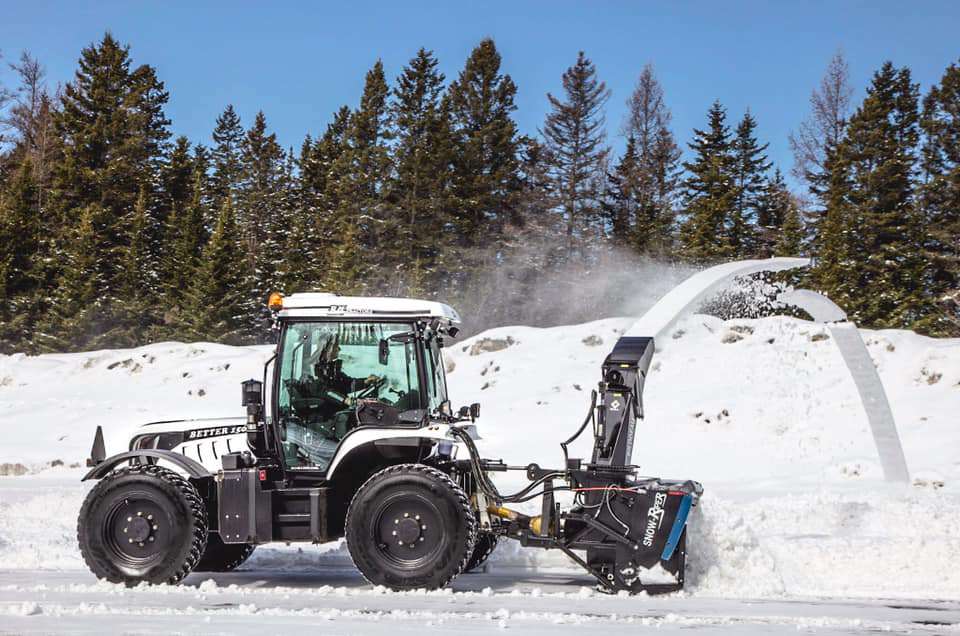 Tractor-mounted commercial snow blower clearing deep snow